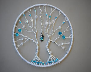 front view 6 inch silver wire tree adorned with blue and clear glass beads featuring blue owl charm swaying between two trees